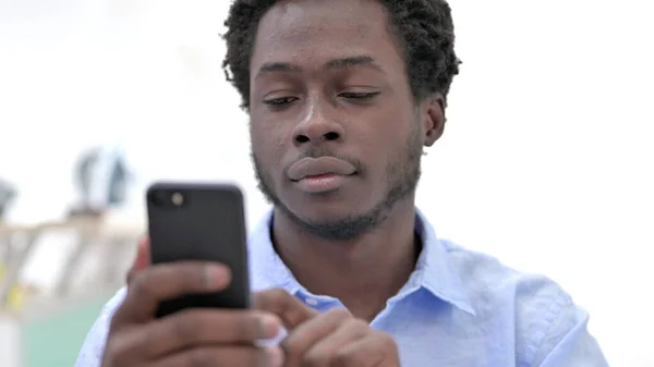 非洲男人在手机上滚动的特写 — 图库照片