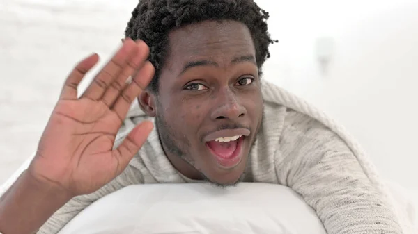 Close-up tiro do homem africano fazendo Video Chat na cama — Fotografia de Stock