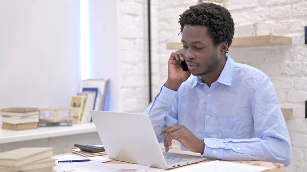 Pracujący Afrykanin rozmawiający przez telefon — Zdjęcie stockowe