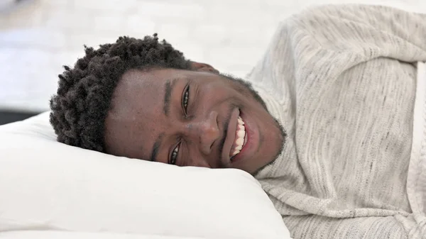 Mladý Afričan mluví, zatímco leží v posteli — Stock fotografie