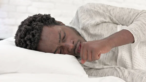 Νεαρός Αφρικανός βήχει στο κρεβάτι — Φωτογραφία Αρχείου