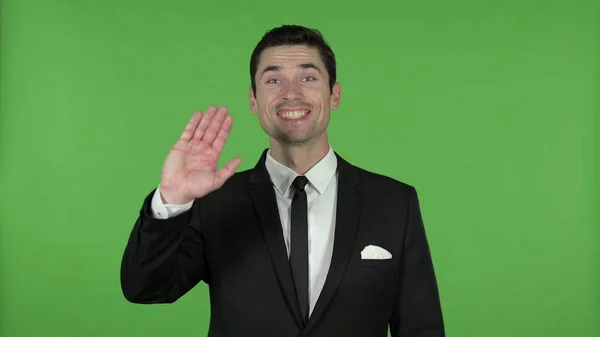 Jovem empresário acenando para a câmera, Chroma Key — Fotografia de Stock