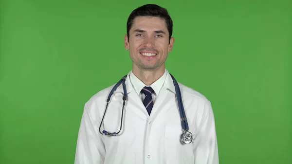 Alegre joven doctor sonriendo en la cámara, clave de croma —  Fotos de Stock