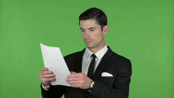 Молодой бизнесмен читает документы, хрома ключ — стоковое фото