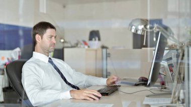 Orta Yaşlı İşadamı Rahatlatıcı Mood Ofis Bilgisayar üzerinde çalışıyor