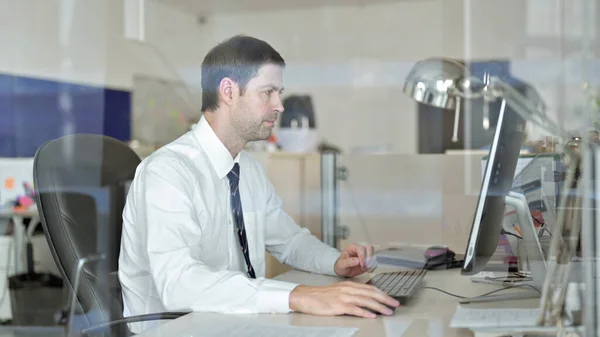 Středozestárlý obchodník pracující v počítači Office — Stock fotografie