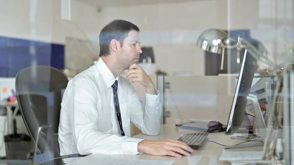 Středozestárlý obchodník myšlení a práce v počítači Office — Stock fotografie