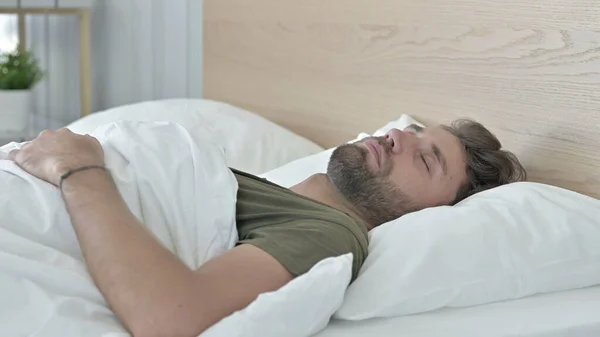 Fiatal férfi alszik az ágyon otthon — Stock Fotó