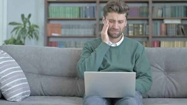 Müder Mann mit Kopfschmerzen bei der Arbeit am Laptop — Stockfoto