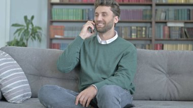 Kanepede Otururken Telefonda Konuşan Genç Adam