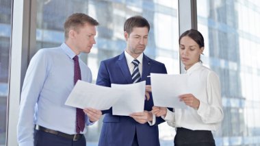 Orta Yaşlı İşadamı Ofisteki Asistanlarına Belgelerde Yardım