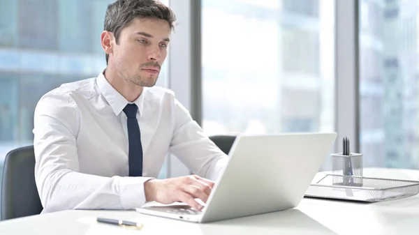 Uomo d'affari di successo che lavora su computer portatile in ufficio — Foto Stock