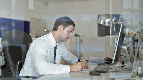 Ambicioso hombre de negocios de mediana edad escribiendo documentos de negocios en la mesa de oficina —  Fotos de Stock