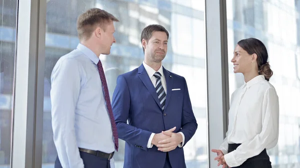 Бизнесмен среднего возраста ведет переговоры со своими помощниками в офисе — стоковое фото