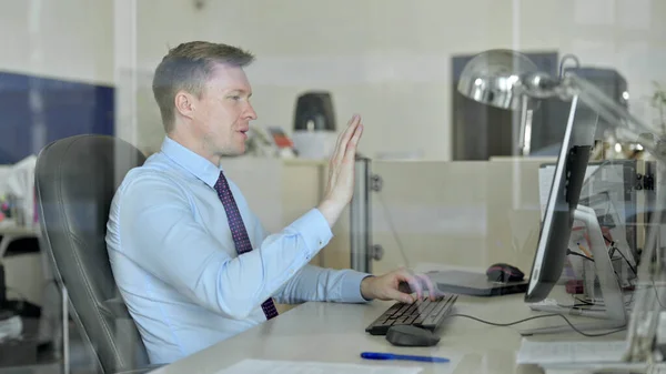 Joven hombre de negocios guapo haciendo Video Chat en la computadora de la oficina —  Fotos de Stock