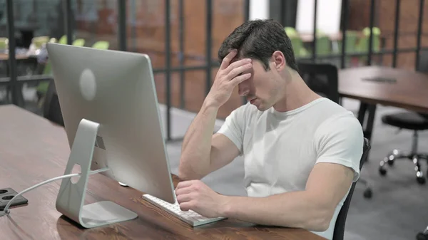 Unavený mladý muž s bolestí hlavy v práci, bolest v hlavě — Stock fotografie