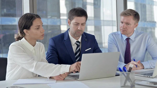 Výkonní obchodní lidé sdílející sestavu přes přenosný počítač v tabulce Office — Stock fotografie