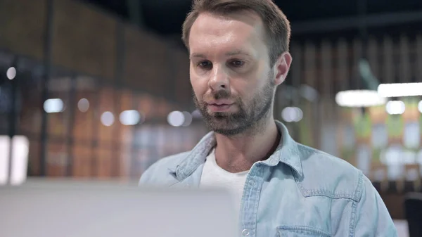 Junger Mann mit Bart arbeitet am Laptop — Stockfoto