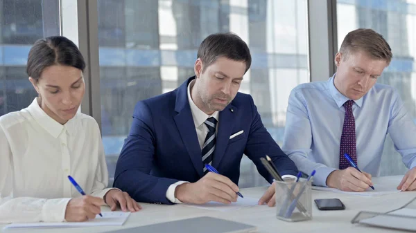 Gente de negocios escribiendo documentos en la mesa de oficina —  Fotos de Stock
