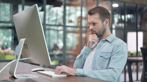 Nachdenkliches junges Designerdenken bei der Arbeit am Computer — Stockfoto