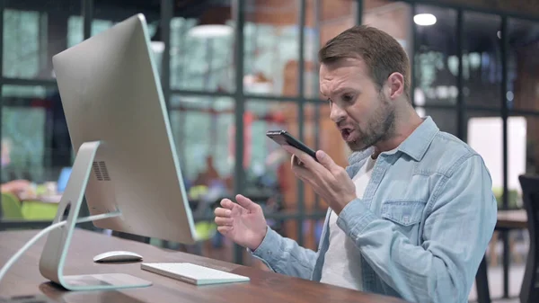 Irritado Jovem Falando no telefone no trabalho — Fotografia de Stock