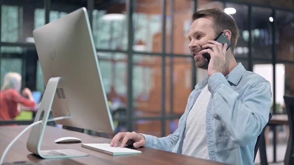 Junger Mann telefoniert bei der Arbeit — Stockfoto