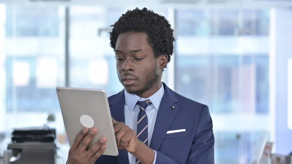 Africký americký podnikatel pomocí tabletu v kanceláři — Stock fotografie
