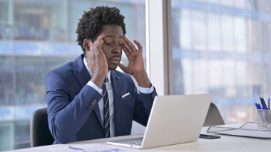 Odaklanmış Afrikalı Amerikalı İşadamı çalışırken baş ağrısı çekiyor