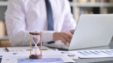 Kum Saati 'ni Masa ve İş Adamı' na Dizüstü bilgisayar kullanarak Kapat