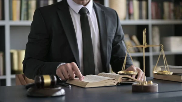 Nahaufnahme eines Anwalts, der ein Buch auf dem Tisch des Gerichtssaals liest — Stockfoto