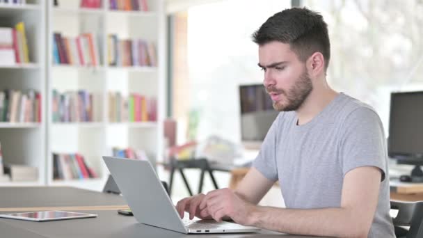 Mladý muž s notebookem s bolestí zad v kanceláři — Stock video