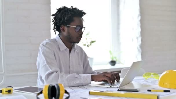 Giovane ingegnere africano con computer portatile sorridente alla fotocamera in ufficio — Video Stock