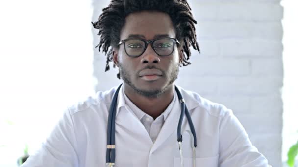 Веселый африканский доктор улыбается перед камерой — стоковое видео