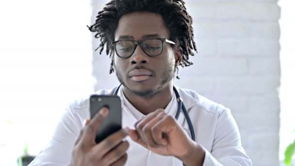 Médico africano enfocado usando Smartphone — Vídeo de stock