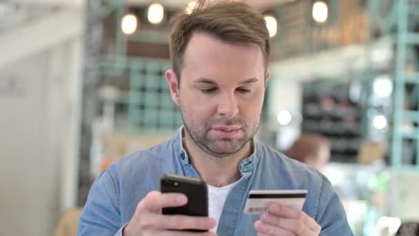 Portret dorywczego mężczyzny po sukcesie płatności online w telefonie — Wideo stockowe