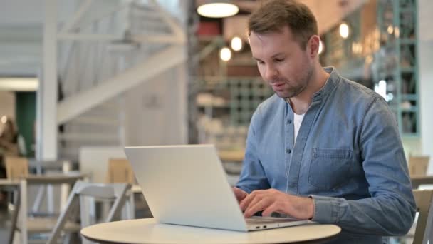 Hombre casual profesional usando el ordenador portátil en Café — Vídeos de Stock