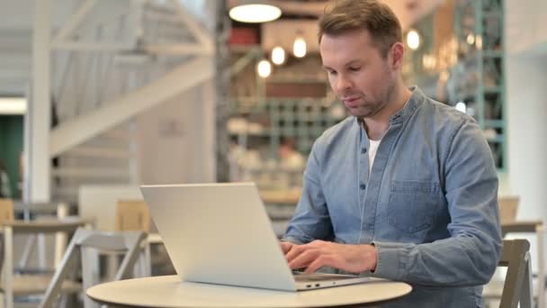 Nenucený muž reagující na ztrátu na notebooku v kavárně — Stock video