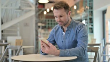 Cafe 'de akıllı telefon kullanan ciddi bir sıradan adam.