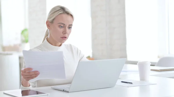 Ung affärskvinna som arbetar med dokument och bärbar dator — Stockfoto
