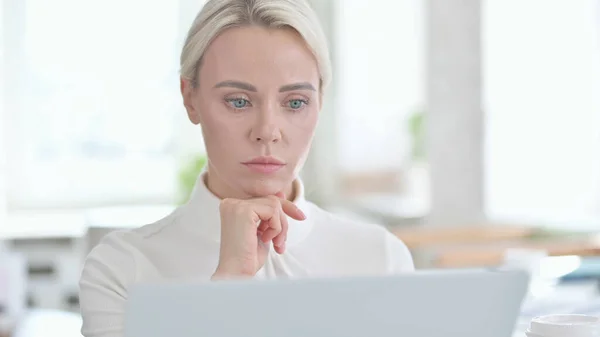 Porträtt av ung affärskvinna tänker och arbetar på laptop — Stockfoto