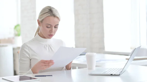 Jeune femme d'affaires lisant des documents dans le bureau moderne — Photo