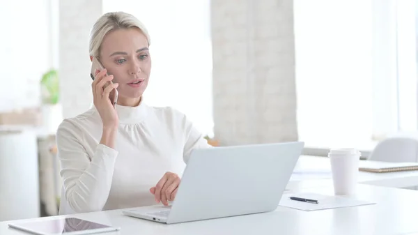 現代オフィスで携帯電話で話している若いビジネスマンの女性 — ストック写真