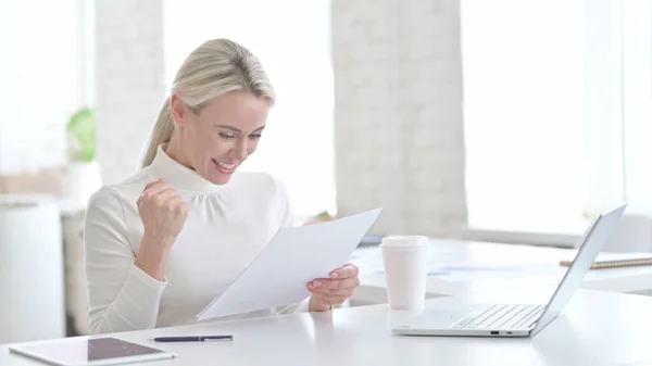 Успешная молодая предпринимательница читает документы в офисе — стоковое фото