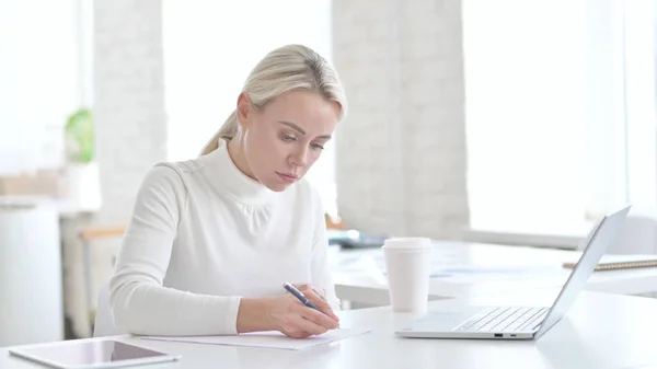 Junge Geschäftsfrau schreibt Dokumente auf Bürotisch — Stockfoto