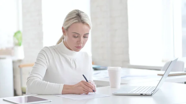 Junge Geschäftsfrau überprüft Dokumente auf Bürotisch — Stockfoto