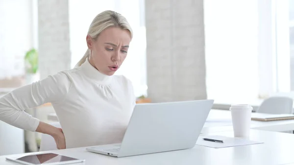 Junge Geschäftsfrau mit Rückenschmerzen im Amt — Stockfoto