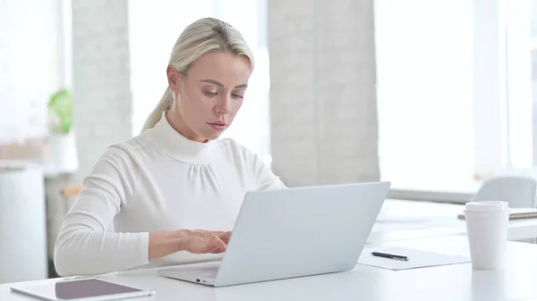 Ehrgeizige junge Geschäftsfrau arbeitet am Laptop — Stockfoto