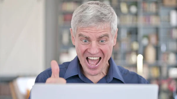 Portret udanego mężczyzny świętującego zwycięstwo podczas pracy na laptopie — Zdjęcie stockowe