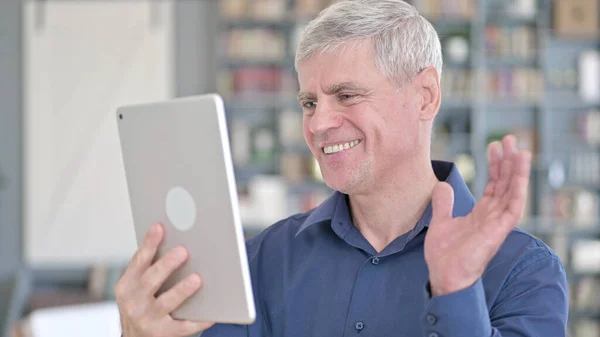 Porträt eines gutaussehenden Mannes mittleren Alters beim Videochat auf dem Tablet — Stockfoto