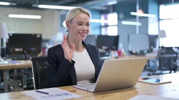 Alegre mujer de negocios haciendo Video Chat en el ordenador portátil en la oficina —  Fotos de Stock